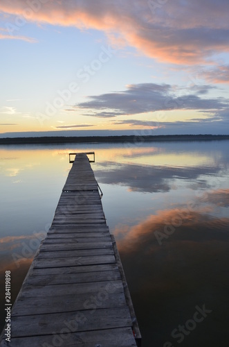 beautiful sunset on Ukrainian lake with a little bridge against the the background of  blue and rose and gray sky 