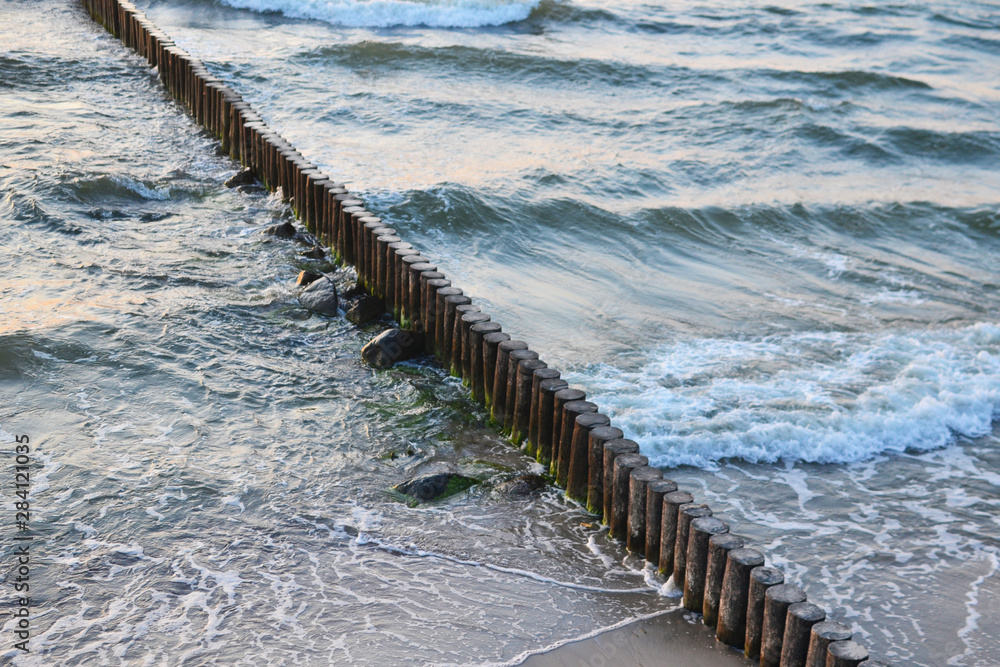 Fototapeta premium waves beat against a breakwater, top view
