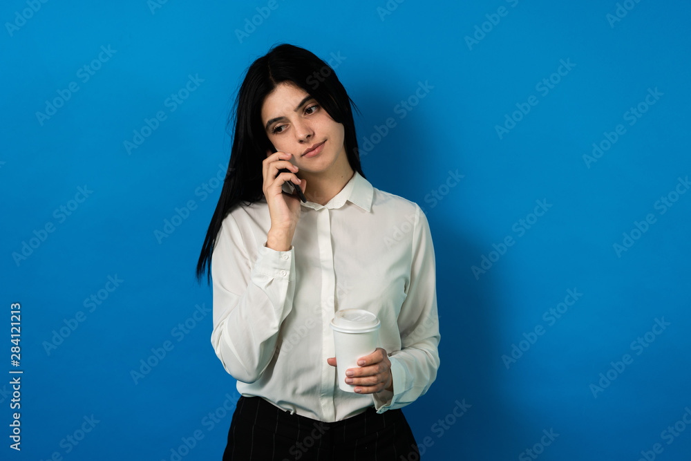 succesfull business woman with smartphone, and coffee are bored. speak with someone not very interested succesfull business woman with smartphone, and coffee are bored. speak with someone not very interested