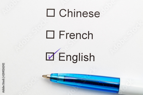 Chinese, French, English - checkmark with pen on paper.