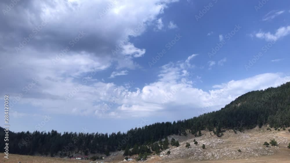 A small village in the mountains with beautiful cumulus clouds, a summer time lapse in the mountains, a beautiful mountain landscape A small village in the mountains with beautiful cumulus clouds, a summer time lapse in the mountains, a beautiful mountain landscape