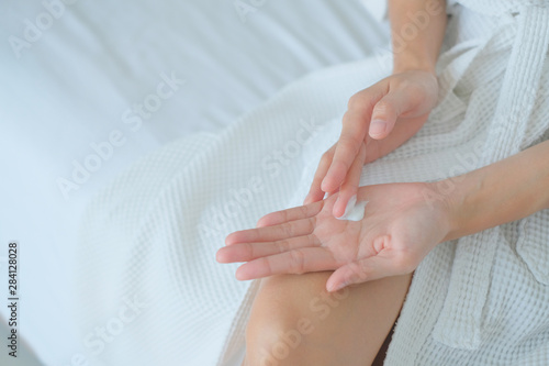 Woman applying moisturizing cream/lotion on hands, beauty concept.