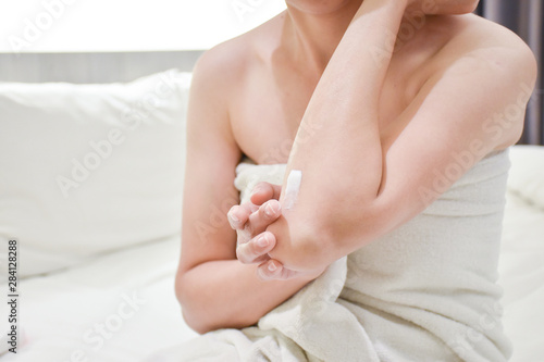 Woman applying elbow cream,lotion , Hygiene skin body care concept. © BoszyArtis