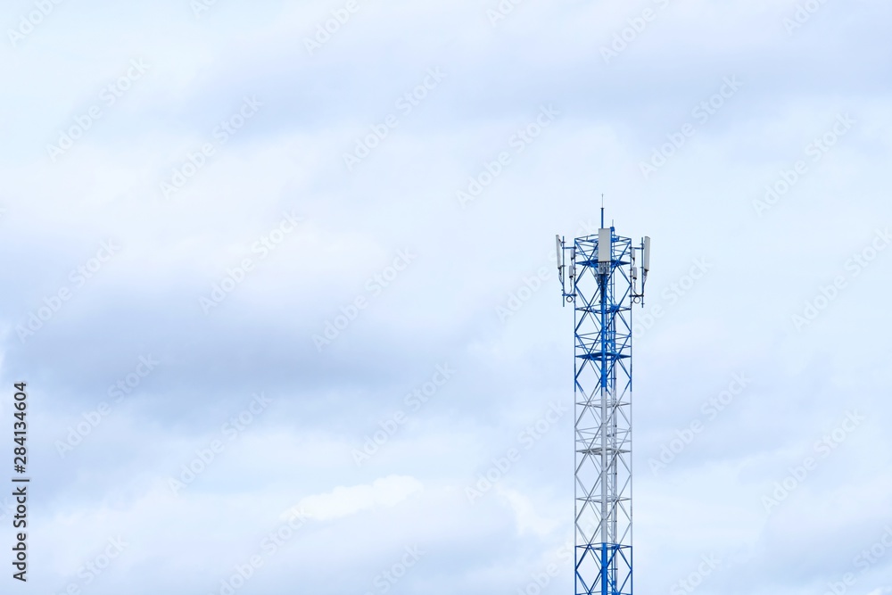 Telecommunication tower with cloudy background.