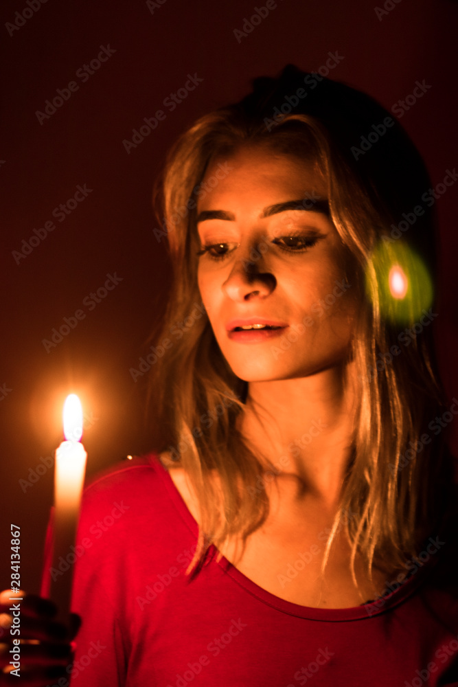 Fototapeta premium blonde girl with candle in red light