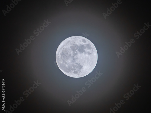 Full moon on the dark night shining on the sky in cloudy day.