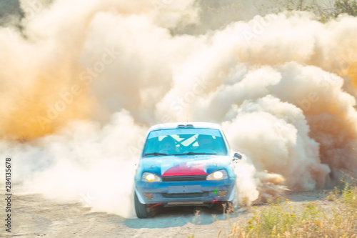 Rally Car is Driving with a Big Cloud of Dust