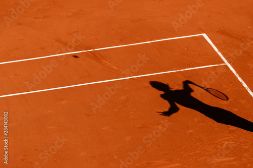 A tennis Clay court and the shadow of a player 