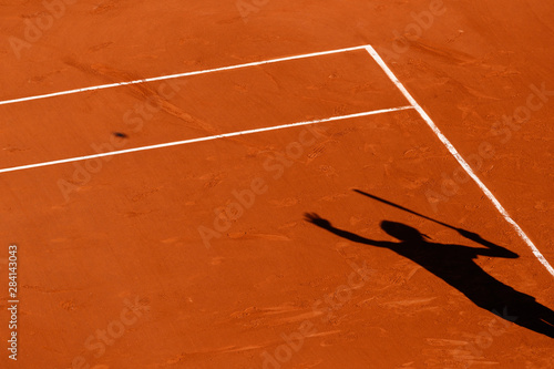 A tennis Clay court and the shadow of a player 