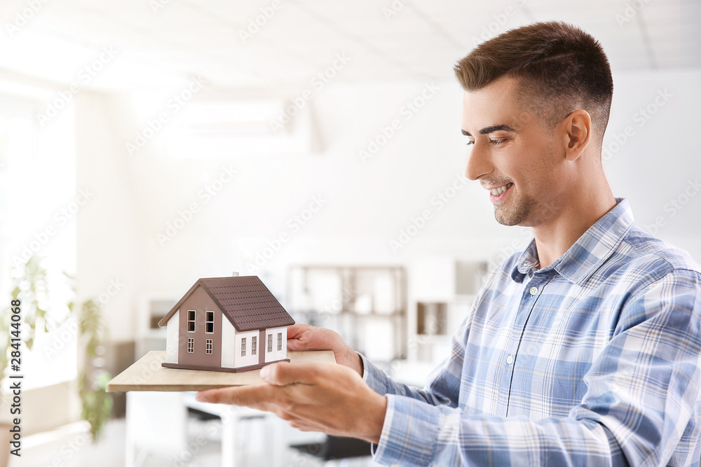 Male architect with model of house in office Male architect with model of house in office