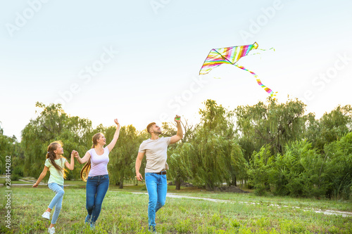 Happy family flying kite ou...