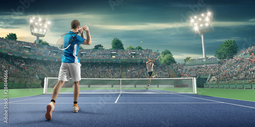 Male athlete plays tennis on a professional court photo