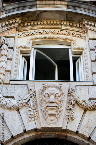 Foto Man head sculpture with ornaments on an old building