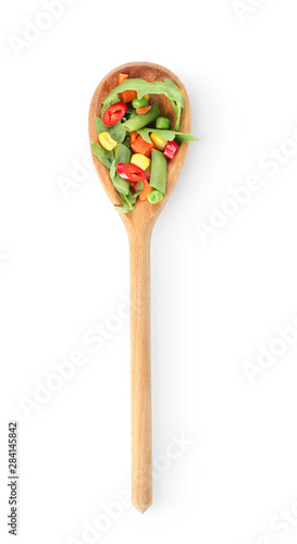 Spoon with fresh arugula and vegetables on white background