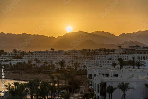 Sharm el Sheikh, Egypt - May, 2019: Panorama of the beach with umbrellas at the reef on sunset, Sharm el Sheikh, Egypt