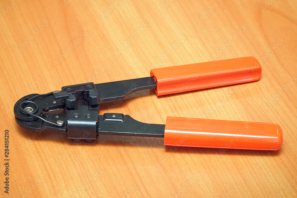 Crimping Tool for computer plugs on wooden background