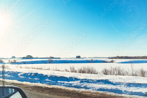 Winter road on the background of the sun in the blue sky