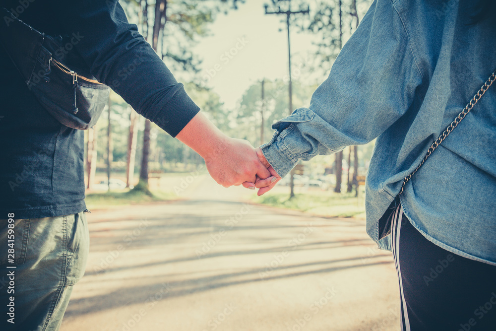 Close up of loving couple holding hands together on the street. Asia tourist have romance time on vacation.