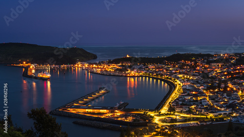 The illuminated harbour / port / marina and city of Horta, Faial Island, Azores Island, Portugal after sunset agains dark sky
