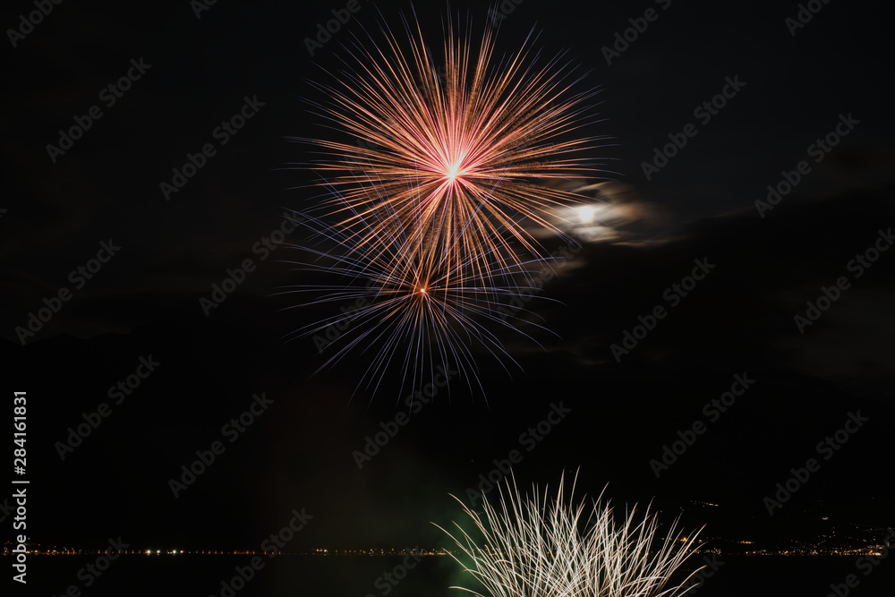 Firework show on Lake Garda. In the city of Limone Sul Garda Italy. Aerial view. Long and charming evening Yellow Night.