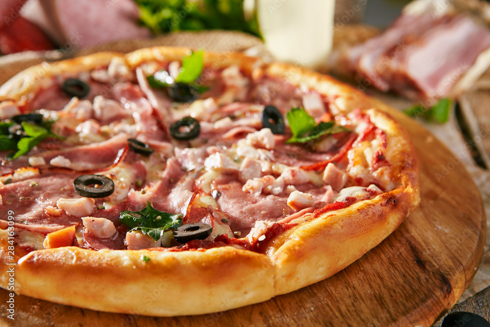 Pizza Restaurant Menu - Delicious Fresh Meat Pizza with Bacon, Sausage and Chicken. Pizza on Rustic Wooden Table with Ingredients