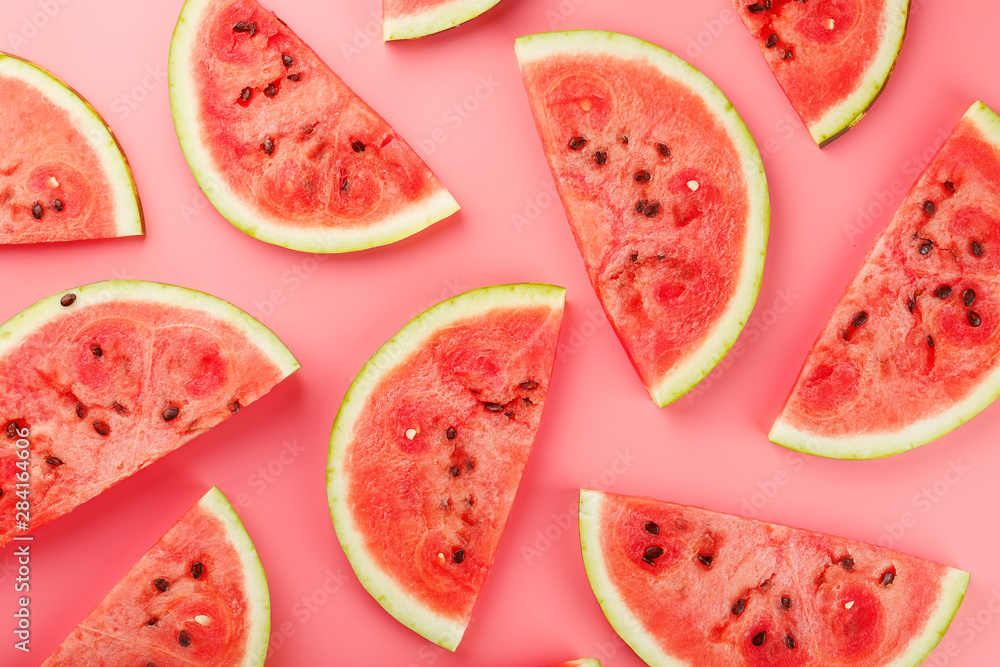 Juicy slices of red watermelon on a bright pink background. Conceptual colors of summer. Patterns top view as a background or substrate - obrazy, fototapety, plakaty 