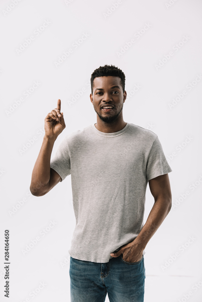 handsome african american man pointing with finger while standing with hand in pocket isolated on white handsome african american man pointing with finger while standing with hand in pocket isolated on white