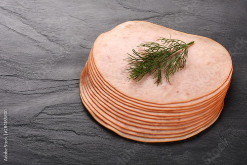 Smoked slices ham on black stone serving plate