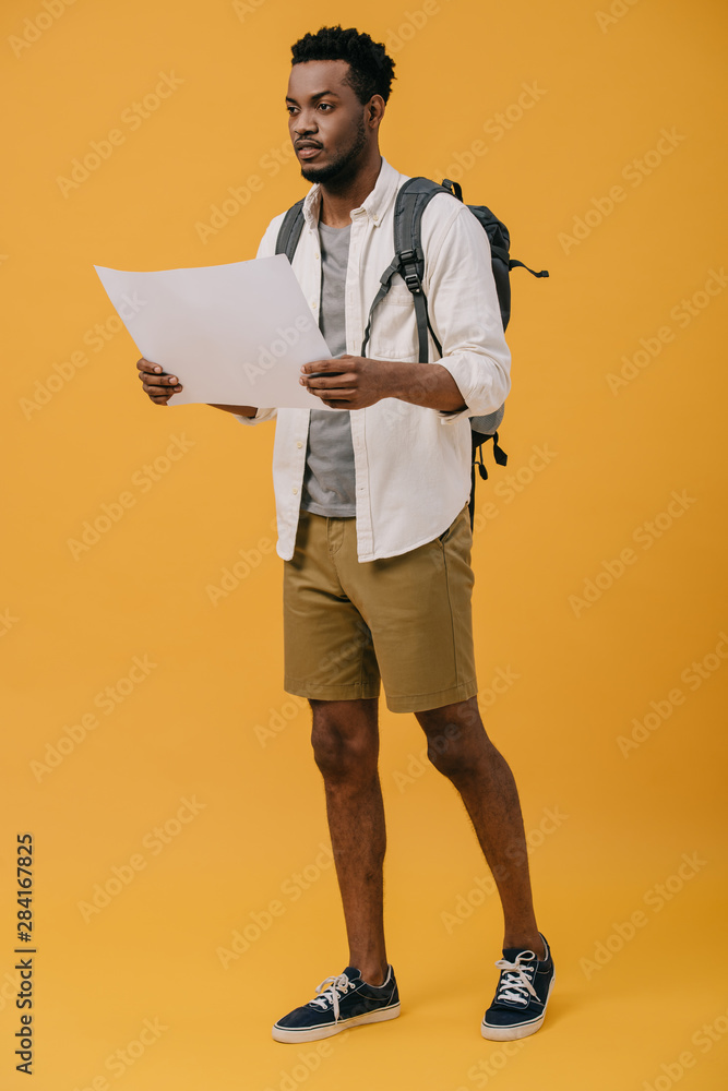 handsome african american man holding blank paper on orange handsome african american man holding blank paper on orange