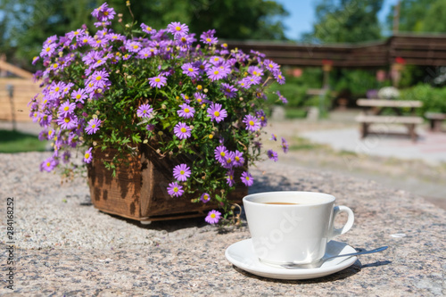 cup of coffee with flowers on table