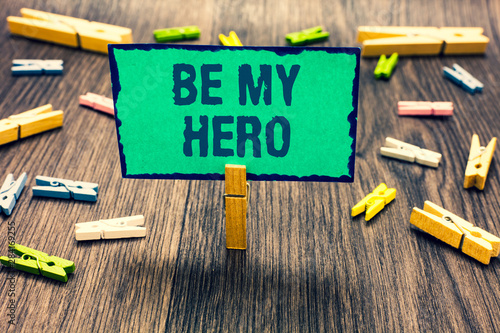 Word writing text Be My Hero. Business concept for Request by someone to get some efforts of heroic actions for him Clothespin holding green paper note several clothespins wooden floor photo