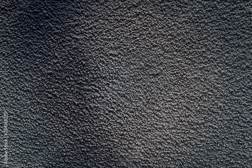 Black texture of an old gray concrete wall. Dark cement backdrop with background on the asphalt.