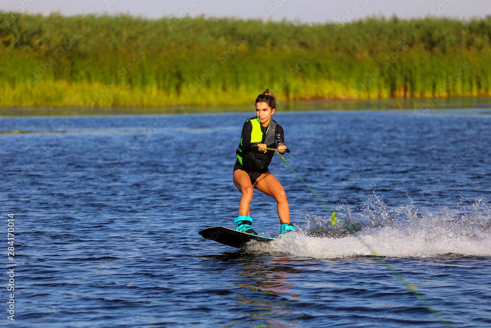 Young Sexy girl Catch waves on wakeboard when boat pulls a wakeboard Young Sexy girl Catch waves on wakeboard when boat pulls a wakeboard