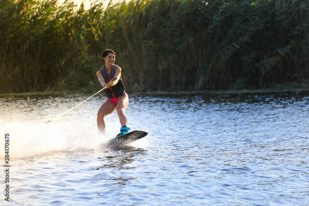 Happy girl riding on wakeboard at sunny day , smiling and happy Happy girl riding on wakeboard at sunny day , smiling and happy