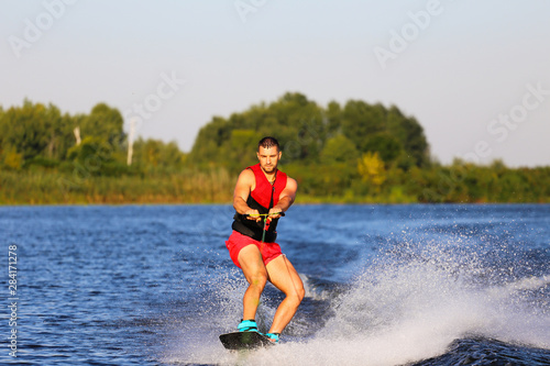 Fototapeta Naklejka Na Ścianę i Meble -  Man making waves on wakeboard 