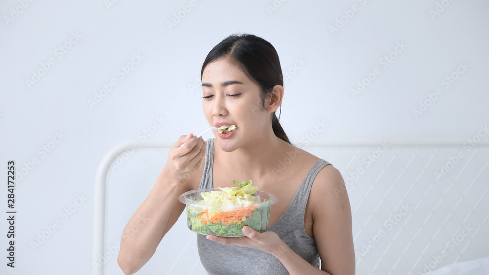 Health concept. Asian girls are eating vegetables salad in the bedroom. Health concept. Asian girls are eating vegetables salad in the bedroom.