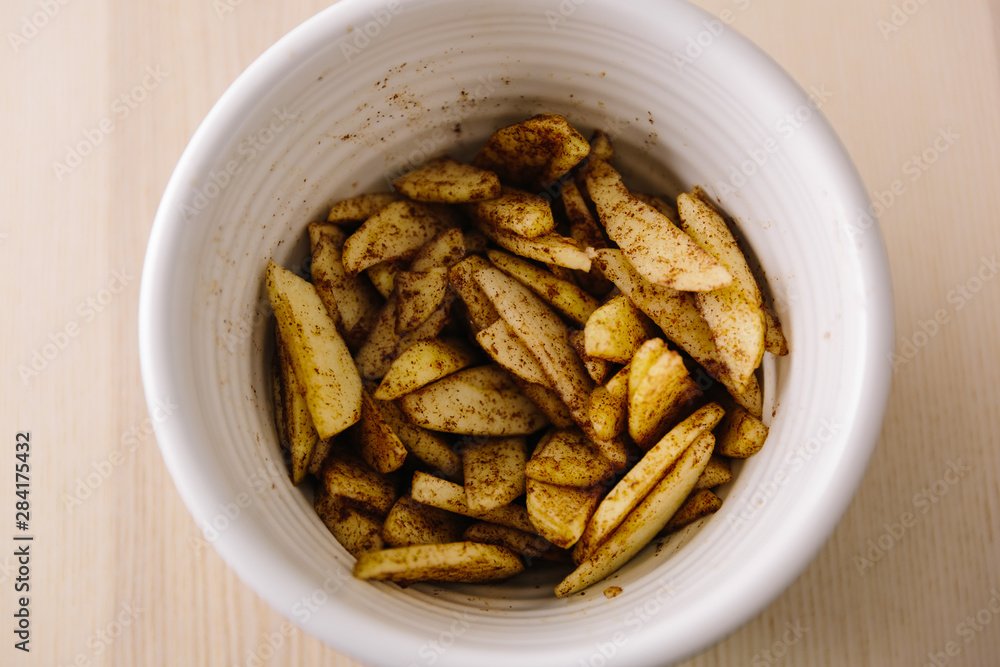 Apple slices coated in brown sugar and ground cinnamon spice Apple slices coated in brown sugar and ground cinnamon spice