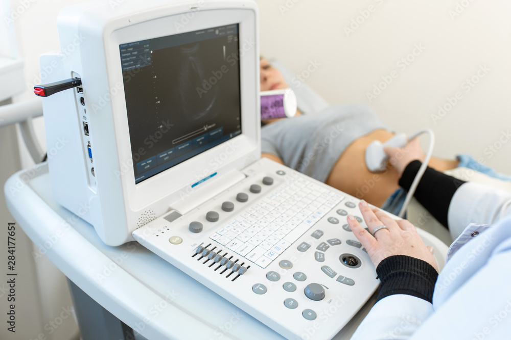 The doctor conducts an ultrasound of the stomach of a young girl. Close-up of equipment The doctor conducts an ultrasound of the stomach of a young girl. Close-up of equipment