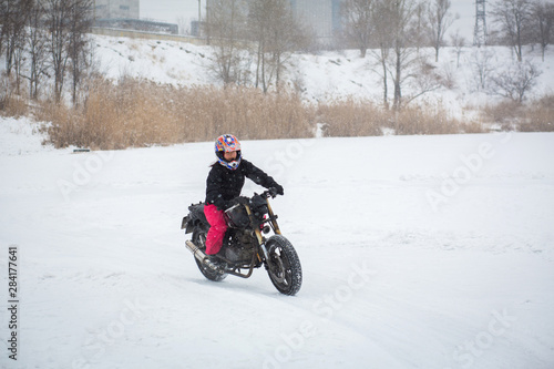 A girl rides a motorcycle on a frozen lake