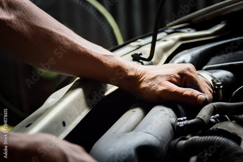 Hand of technician repair and maintenance engine of automobile in service station