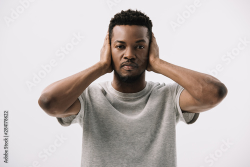 african american man covering ears isolated on white