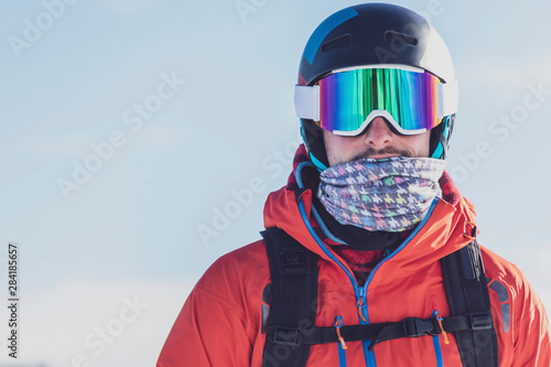 Man with ski goggles and skiing helmet in front of light background, Saalbach Hinterglemm, Pinzgau, Austria photo