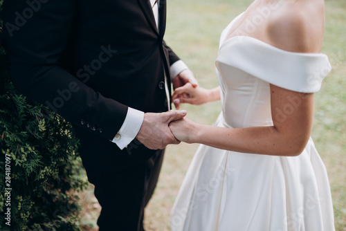 bride and groom holding hands close-up