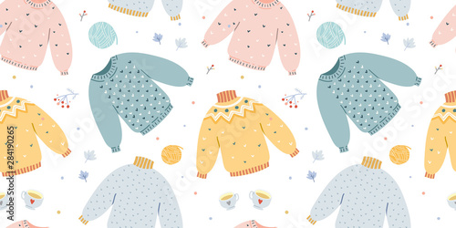 Handdrawn vector illustrations of warm winter and autumn woolen sweaters in pastel scandinavian style colors made as vector seamless pattern. Trendy flat design elements of winter clothes.
