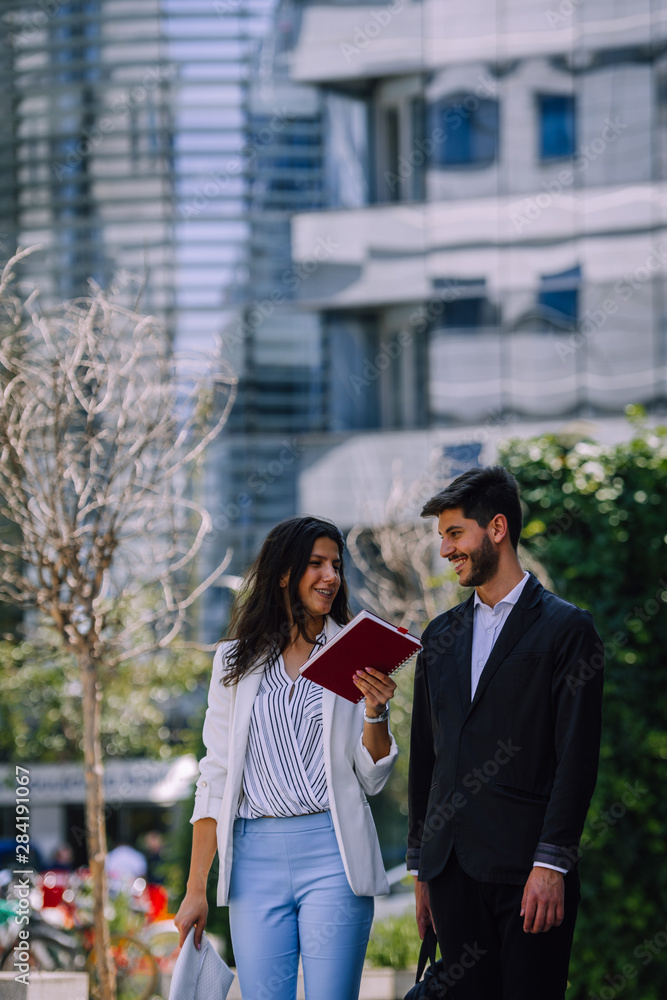 Business colleagues talking on break from work while reading document