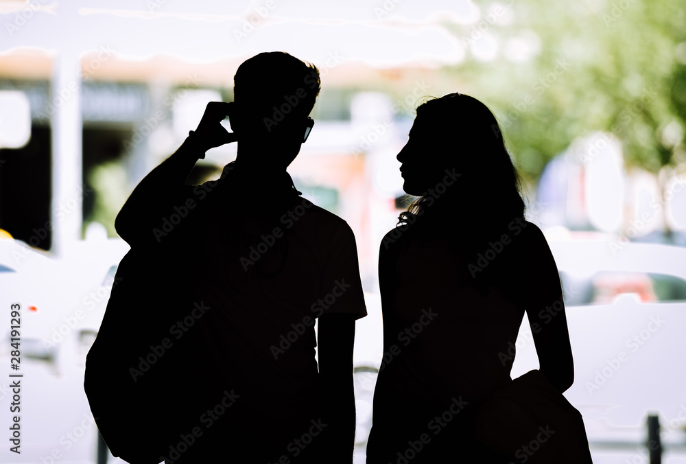 Attractive young silhouette couple standing together in the city