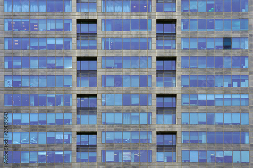Glass grey and blue square Windows of modern city business building skyscraper. Modern apartment buildings in new neighborhood. Windows of a building, texture.    