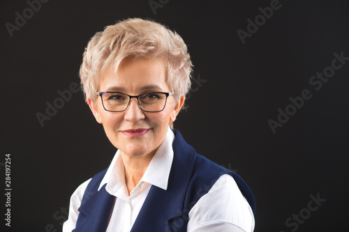 portrait of an adult woman with glasses on black background