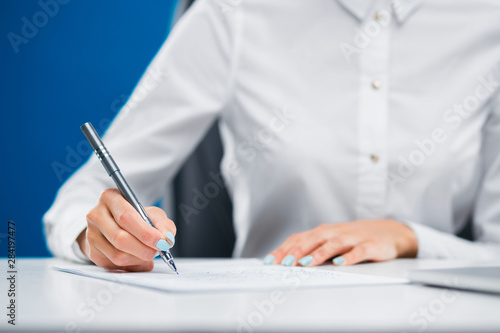 Businesswoman writing down on a sheet of paper innovative ideas.