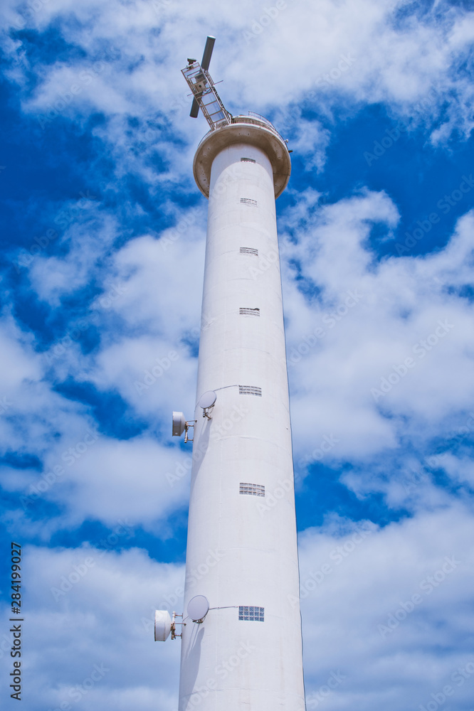 lighthouse near Playa Blanca in Lanzarote called Faro de Punta Pechiguera against blue cloudy sky lighthouse near Playa Blanca in Lanzarote called Faro de Punta Pechiguera against blue cloudy sky